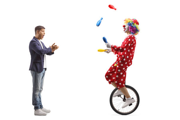 istock Amazed man clapping and watching a clown juggling on a mono cycle 2196541825