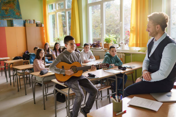 istock A boy plays the guitar in music class 2196543603