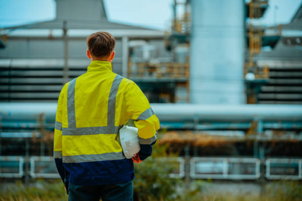 istock Worker in high visibility jacket observes industrial facility during overcast afternoon 2196544180