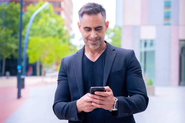 istock Confident businessman using smartphone outdoors, 2196545519