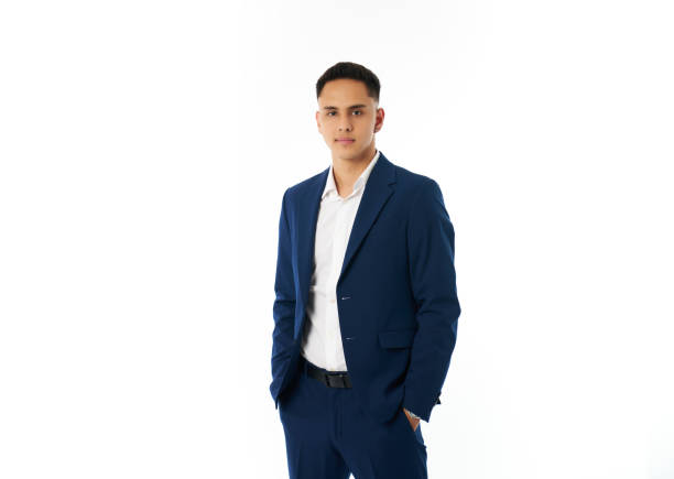 Studio portrait of a confident young businessman posing with his hands in his pockets, exuding professionalism and style against a clean white backdrop