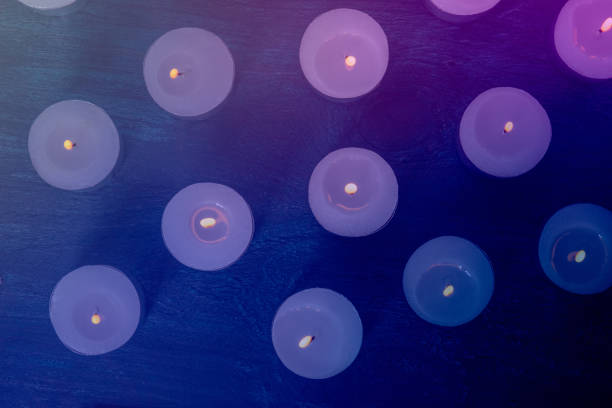 Tea light candles on a dark background, many lights in the dark, candlelight, toned image