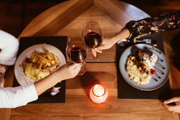 istock Two People Toasting with Glasses of Wine at a Restaurant Table 2196550870