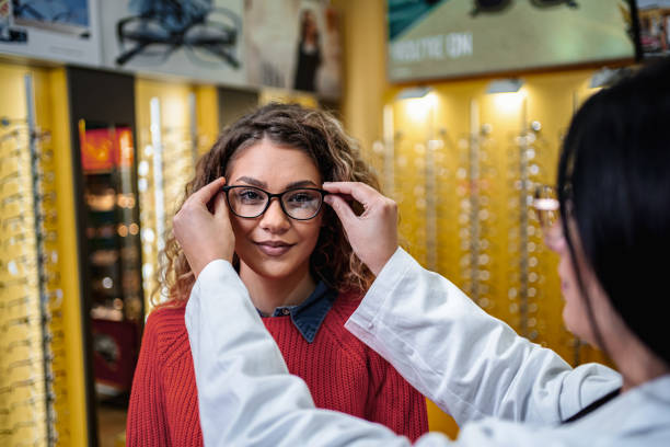 istock Optician adjusting glasses for young woman 2196551606