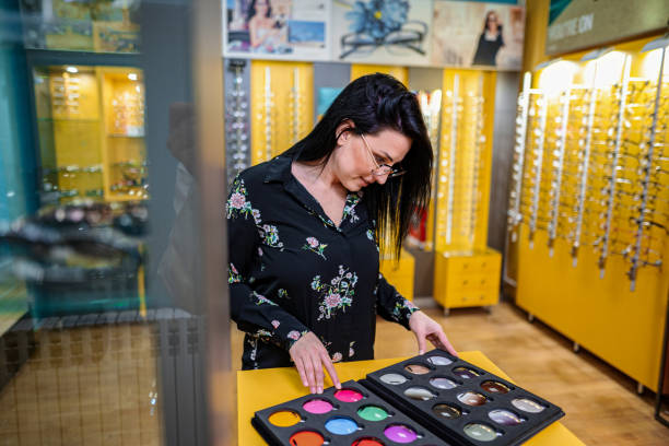 istock Optician choosing colorful lens for eyeglasses in optical store 2196552135