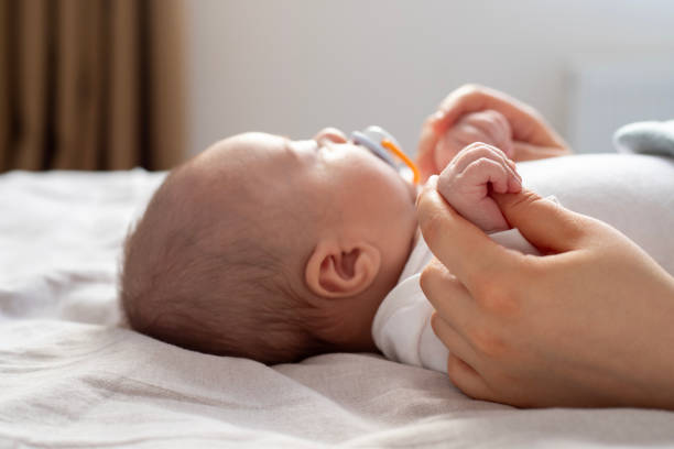 istock Baby Boy Holding Mothers Hand 2196555833