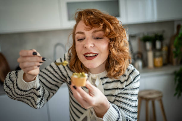 istock Young woman eating fresh avocado bruschetta in her kitchen 2196560118