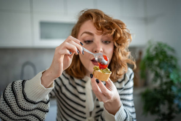 istock Young woman making and eating bruschetta in her kitchen 2196560250