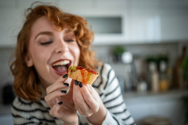 istock Young woman making and eating bruschetta in her kitchen 2196560326