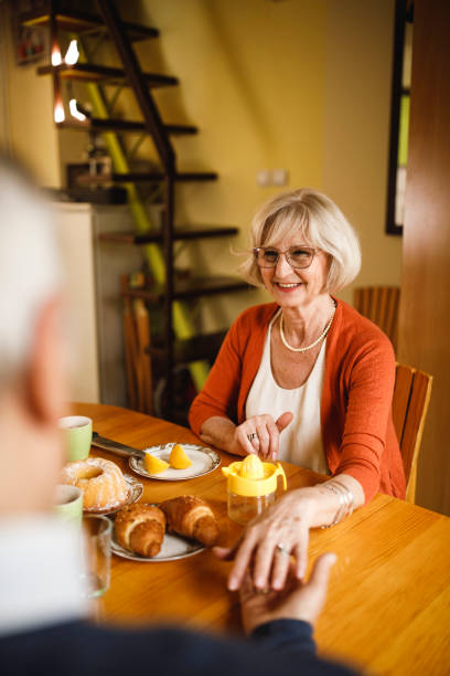 istock Charming senior woman holding hands with her husband during breakfast 2196560716