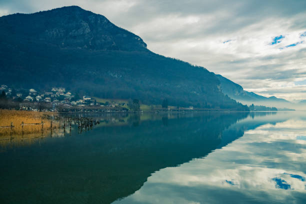 Une vue du Lac d'Annecy avec un ponton. Les hautes montages enneigées. C'est l'hiver.