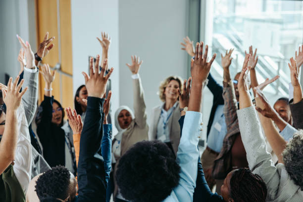 istock Diverse business group raising hands at conference event for team building and collaboration 2196563247