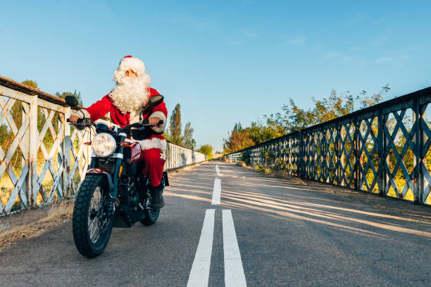 istock santa claus riding a motorcycle on the road 2196564393
