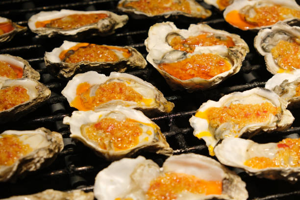 Grilled oysters with garlic. Cooking seafood on grill
