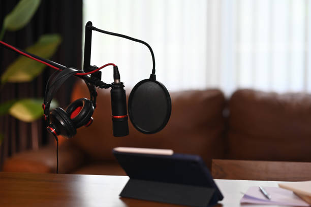 istock Ready for Podcast Recording, A professional podcast setup with a microphone, headphones, and a tablet, prepared for recording in a cozy studio environment 2196573163