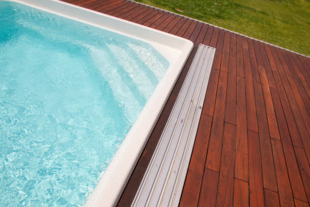 istock Relaxing afternoon by a clear swimming pool surrounded by beautiful wooden decking 2196576680