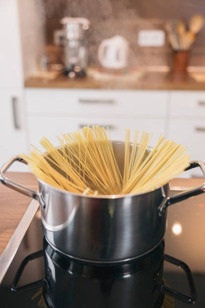 istock Cooking spaghetti in a pot on the stove in a modern kitchen 2196578249