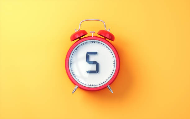 Red Alarm Clock with White Inside and Black Digit 5 on Yellow Soft Background
