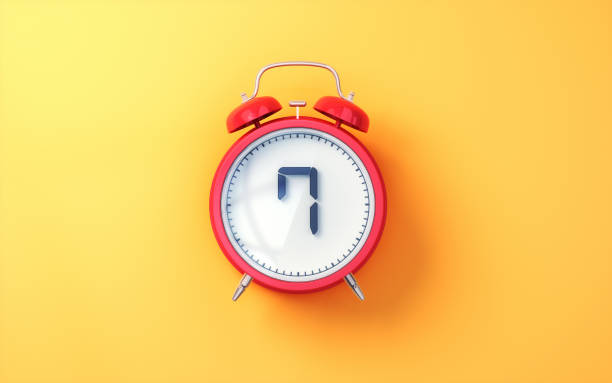 istock Red Alarm Clock with White Inside and Black Digit 7 on Yellow Soft Background 2196580197
