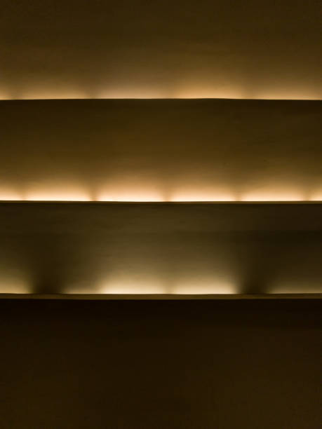 istock Warm cornice lighting. Horizontal blinds with light shining through the slats, creating a striped pattern of light and shadow. 2196580811