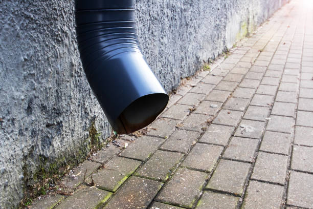 Downspout on the wall above the pavement close up