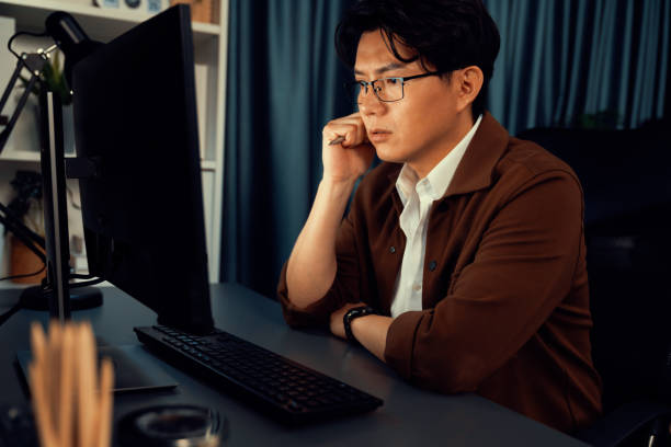 istock Businessman focusing computer business plan report over late night. Infobahn. 2196584006