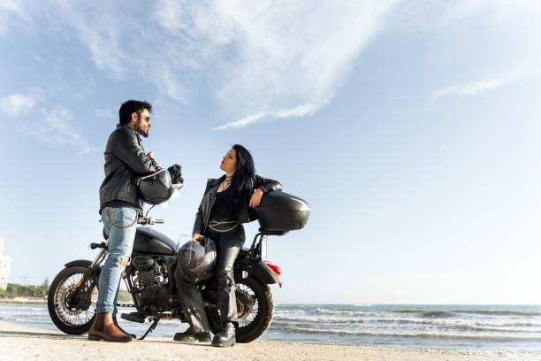 istock Bikers couple talking on the beach with their motorcycle 2196591342