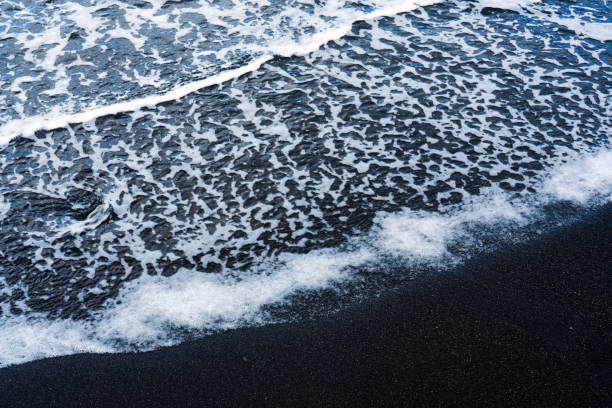 istock Ocean wave white foam on black sand beach 2196592079