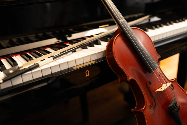 istock Violin on top of piano keyboard background 2196593397
