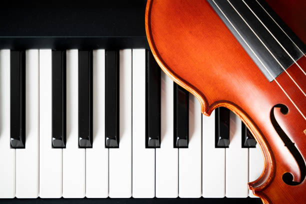istock Violin on top of piano keyboard background 2196593519