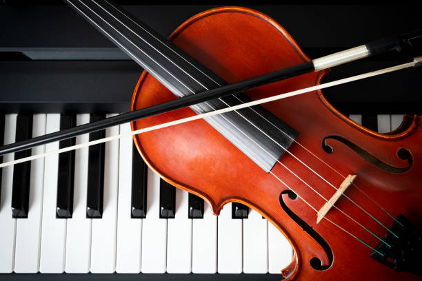 istock Violin on top of piano keyboard background 2196593586
