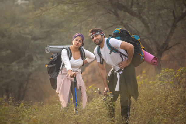 istock Tired young couple with backpacks standing in forest 2196596619