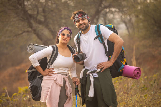 istock Tired young couple with backpacks standing in forest 2196596654