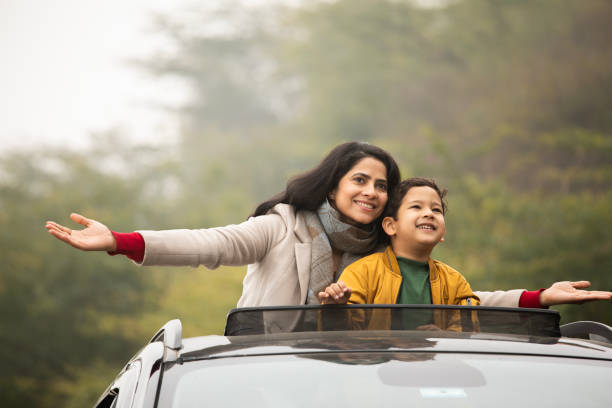 istock Mother and son enjoying road trip while looking through sun roof 2196596974