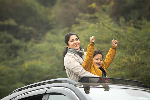 istock Mother and son enjoying road trip while looking through sun roof 2196597324