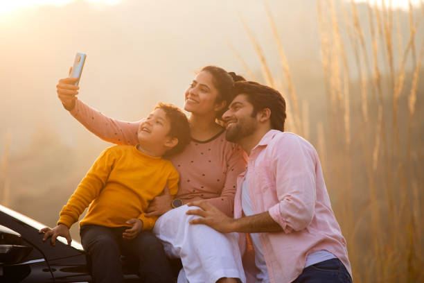 istock Happy family taking selfie over mobile phone during sunset 2196605952