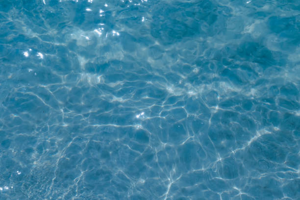 istock Overhead view of blue water surface abstract. Wave on moving water surface close up in the middle of the screen. Blue ocean water with waves background 2196608940
