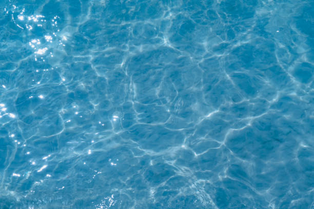 Overhead view of blue water surface abstract. Wave on moving water surface close up in the middle of the screen. Blue ocean water with waves background