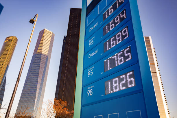 Madrid, Spain. Electronic sign displaying increasing prices of gasoline and diesel in front of modern skyscrapers in a financial district