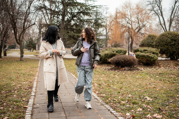 Two girls walking and talking in the park