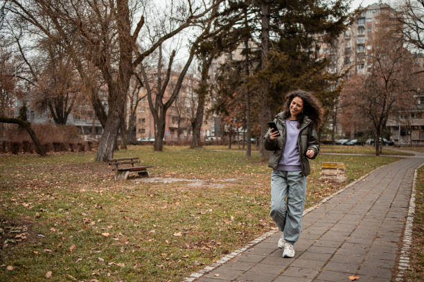 istock Walking in the park and using phone 2196611182