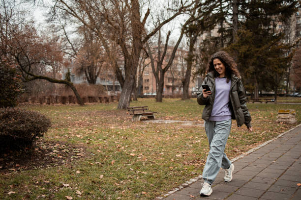 istock Walking in the park and using phone 2196611235