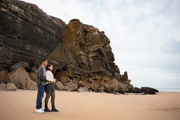 istock Couple on rocky coast on the beach 2196611473