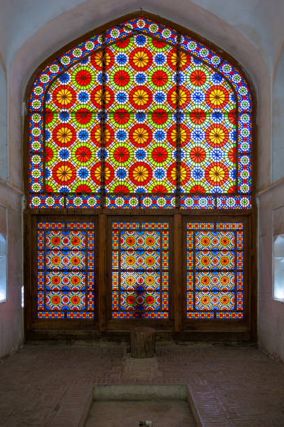 Traditional iranian architecture showcasing a vibrant stained glass window with intricate colorful patterns, creating a mesmerizing play of light and color. Yazd, iran