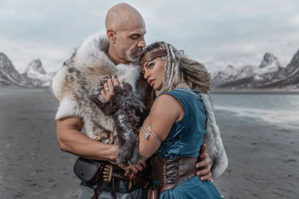 A beautiful viking warrior couple on the beach with mountains