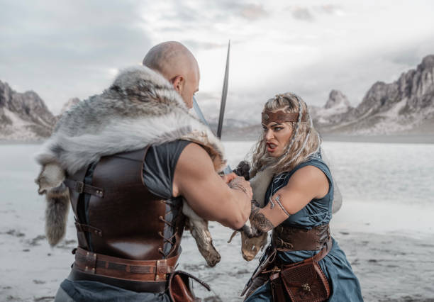 A beautiful viking warrior couple on the beach with mountains