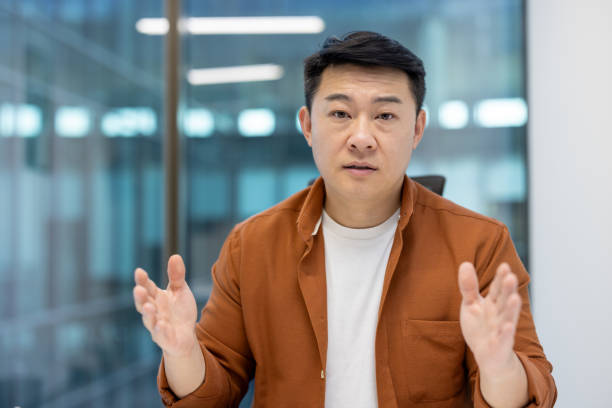 istock Serious focused man looking at camera close up, asian man talking using video call, businessman explaining at online business meeting conference 2196622286