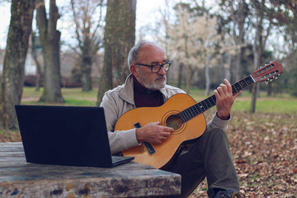 istock Senior man learning to play guitar online 2196624344