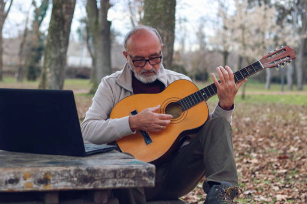 istock Senior man learning to play guitar online 2196624352