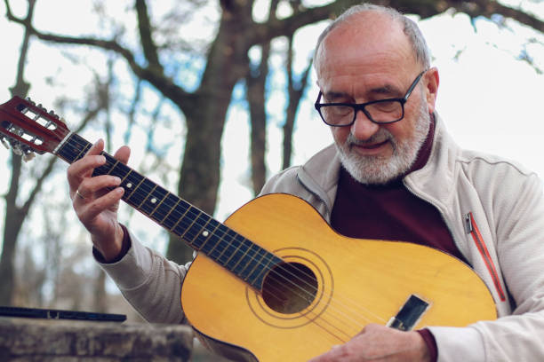 istock Senior man learning to play guitar online 2196624361